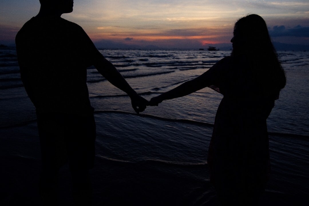 Silhouette of a couple holding hands at sunset